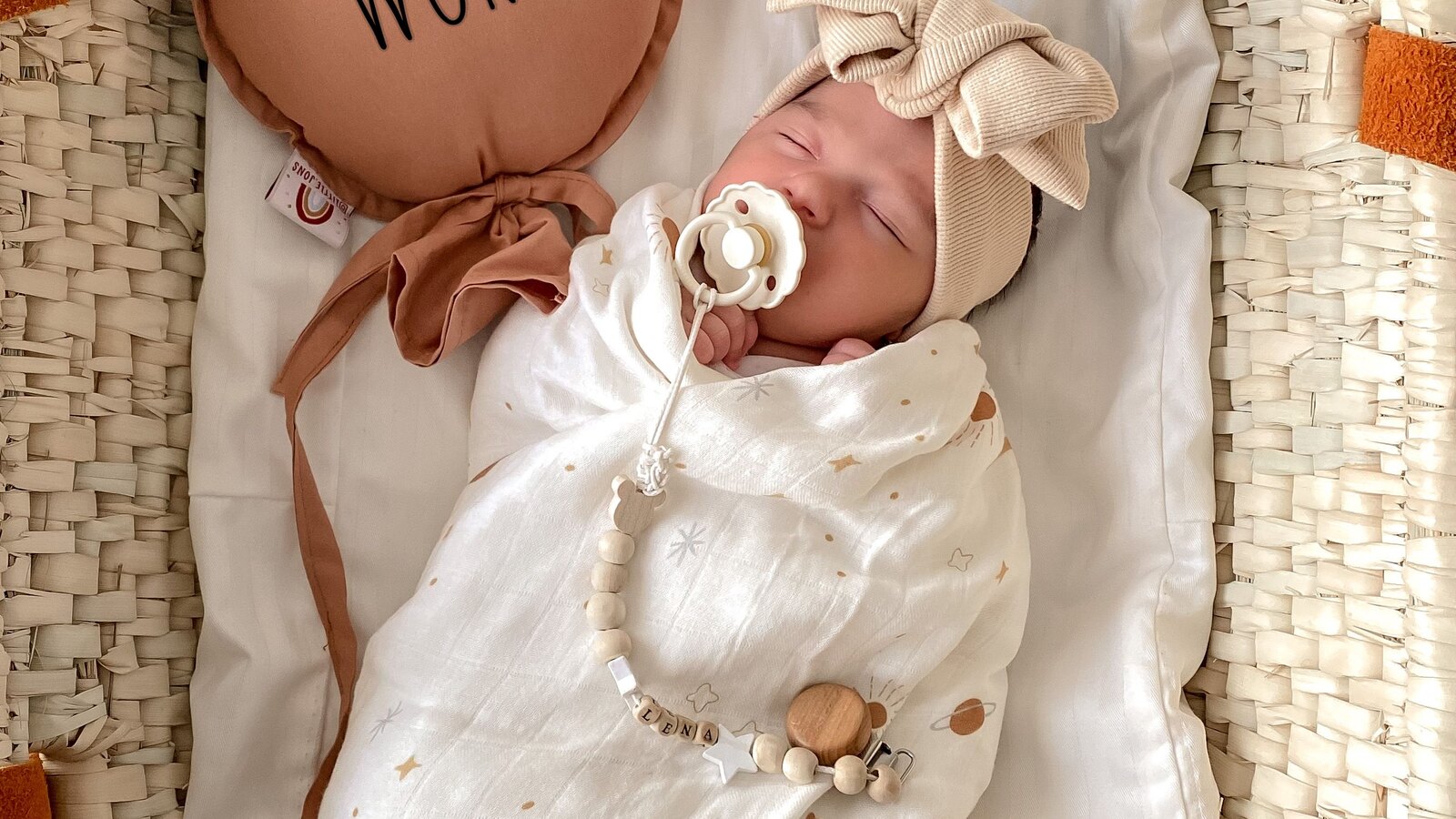 A newborn baby swaddled and sleeping in soft light